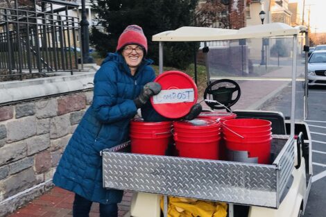 Lisa Miskelly with compost materials in red buckets