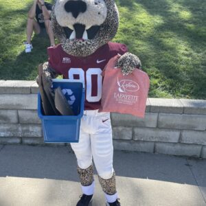 Roary the Leopard mascot holds a recycling bin and a red LaFarm tote bag